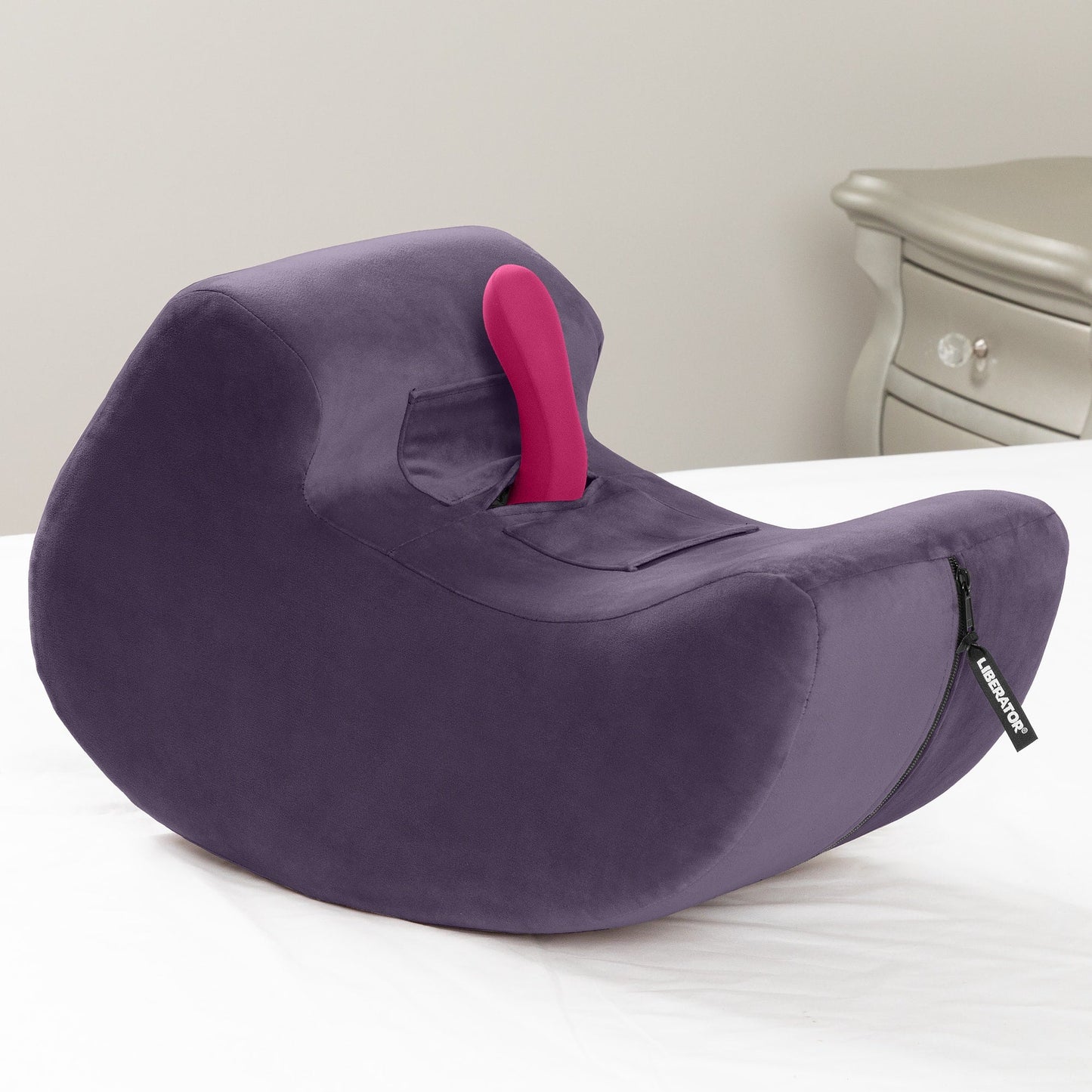 An aubergine Pulse Toy Mount, Bedroom Furniture by Liberator with a toy in the mount sitting on a bed.