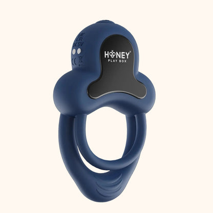 A dark blue Anello Honey Play Box cock ring againt a white background.