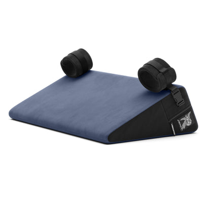 A blue Bondage Wedge, Bedroom Furniture by Liberator with handcuffs on a white background.