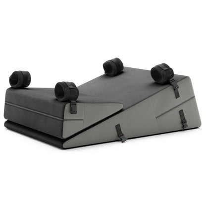 A set of grey ultraleather Bondage ramp and wedge, Bedroom Furniture by Liberator with handcuffs on a white background.