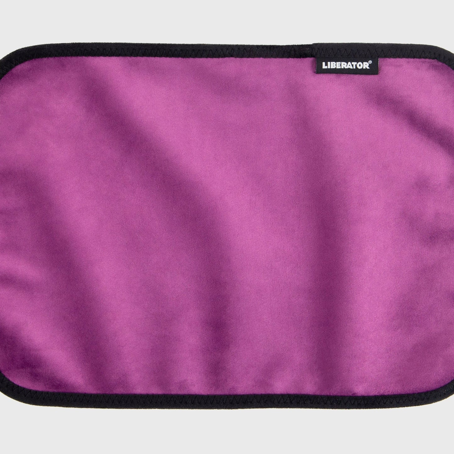 A aubergine Fascinator Splashproof Throws, Bedroom Furniture by Liberator unrolled up against a white background.