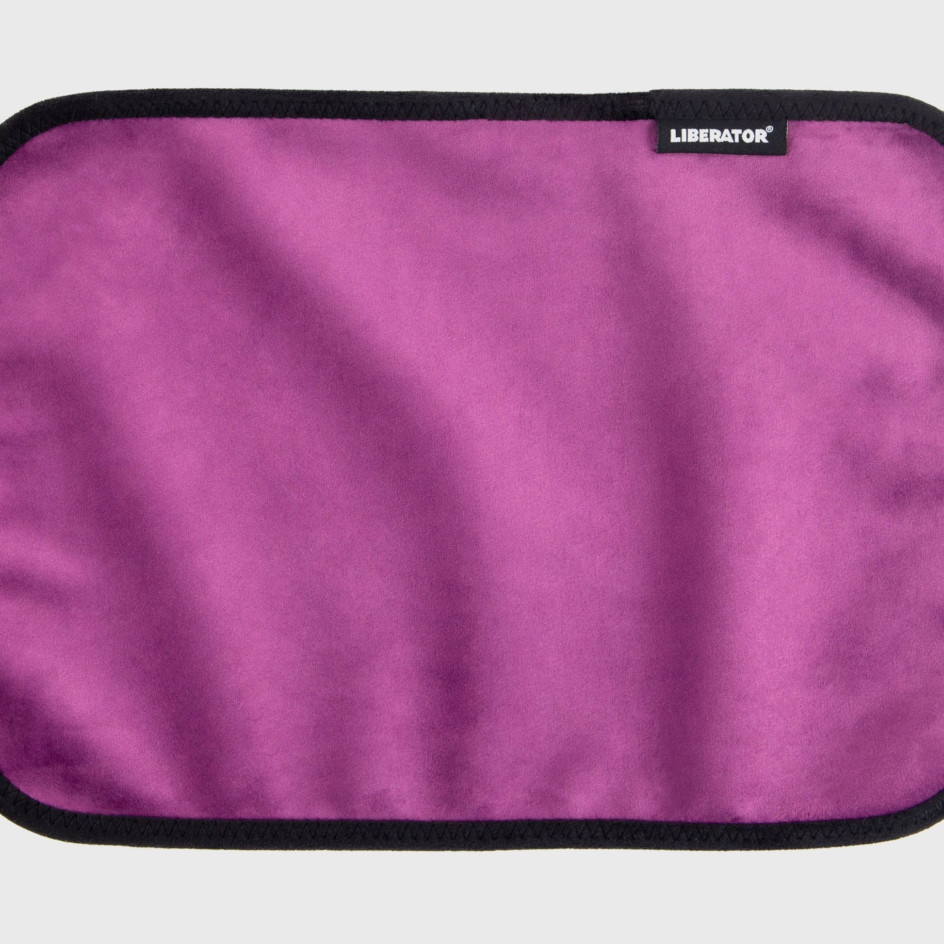 A aubergine Fascinator Splashproof Throws, Bedroom Furniture by Liberator unrolled up against a white background.