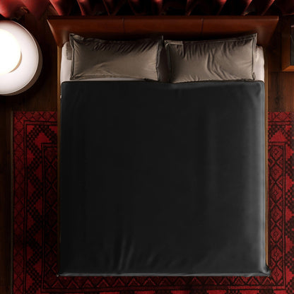 A king size black Fascinator Splashproof Throws, Bedroom Furniture by Liberator sitting on a bed.