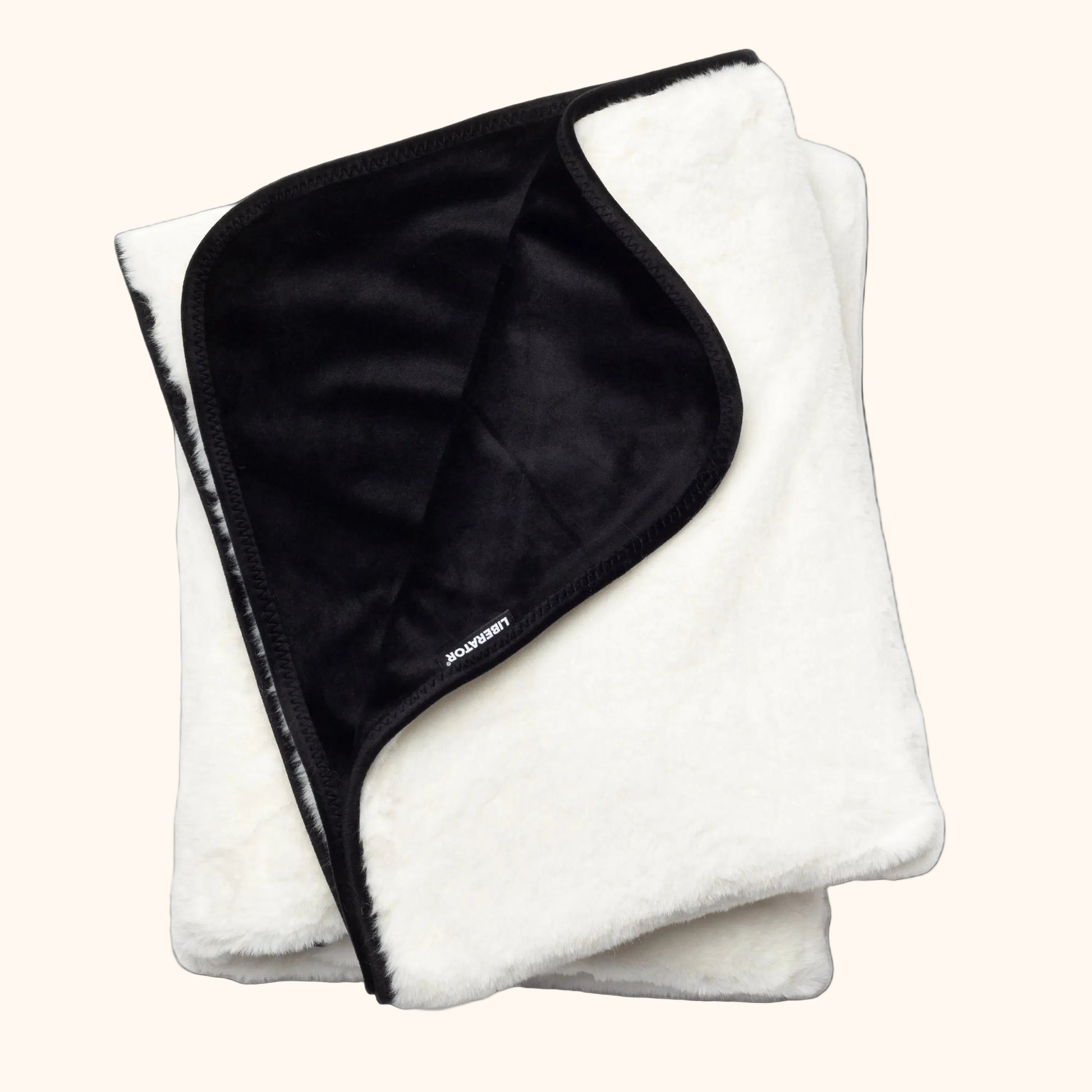 A white faux fur Fascinator Splashproof Throws, Bedroom Furniture by Liberator against a white background.
