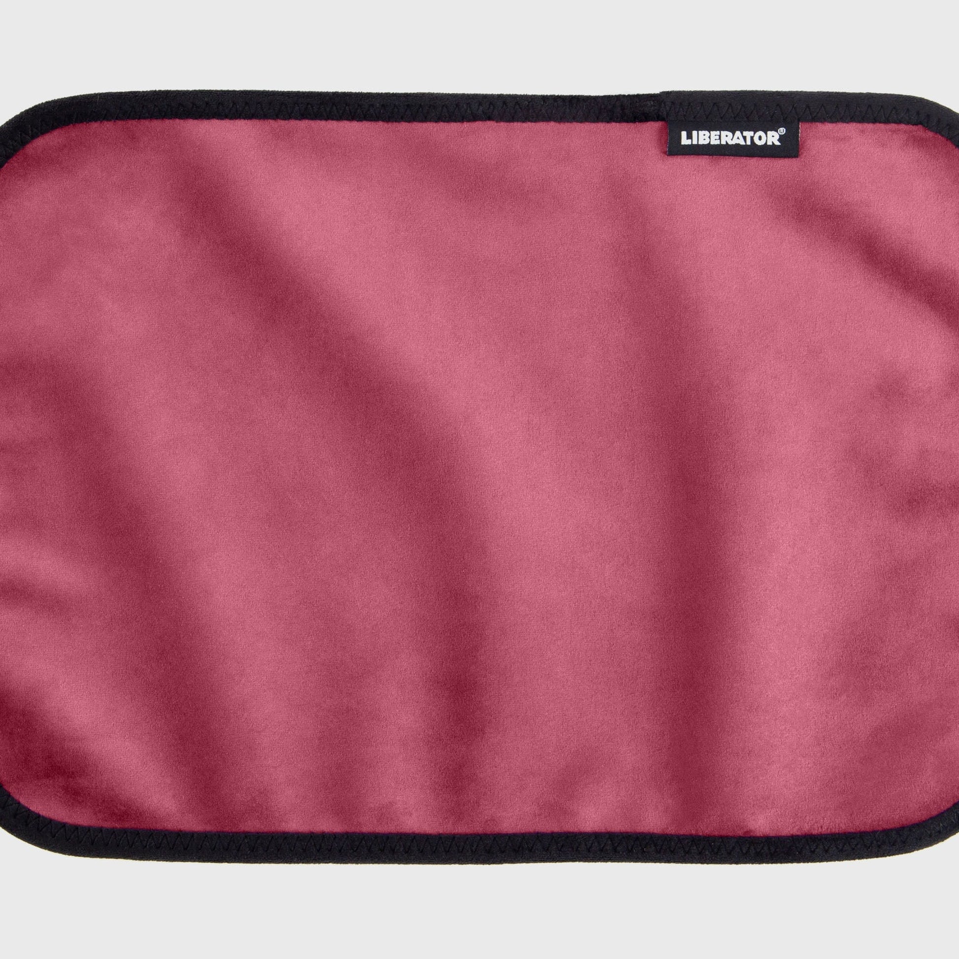 A merlot Fascinator Splashproof Throws, Bedroom Furniture by Liberator unrolled up against a white background.