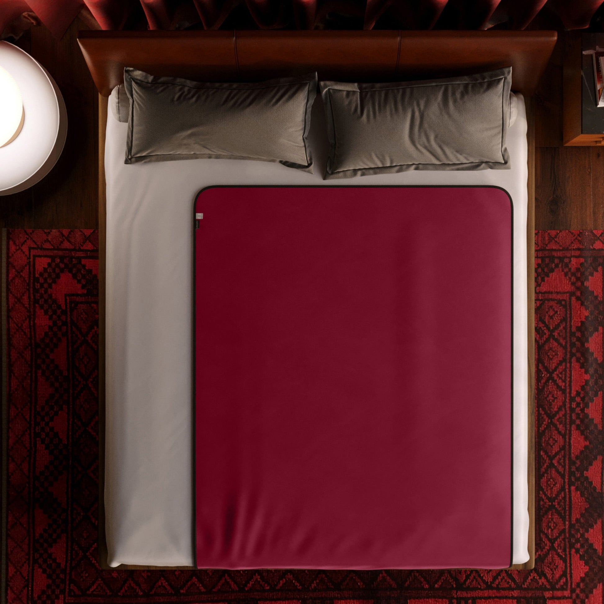 A regular size red Fascinator Splashproof Throws, Bedroom Furniture by Liberator sitting on a bed.