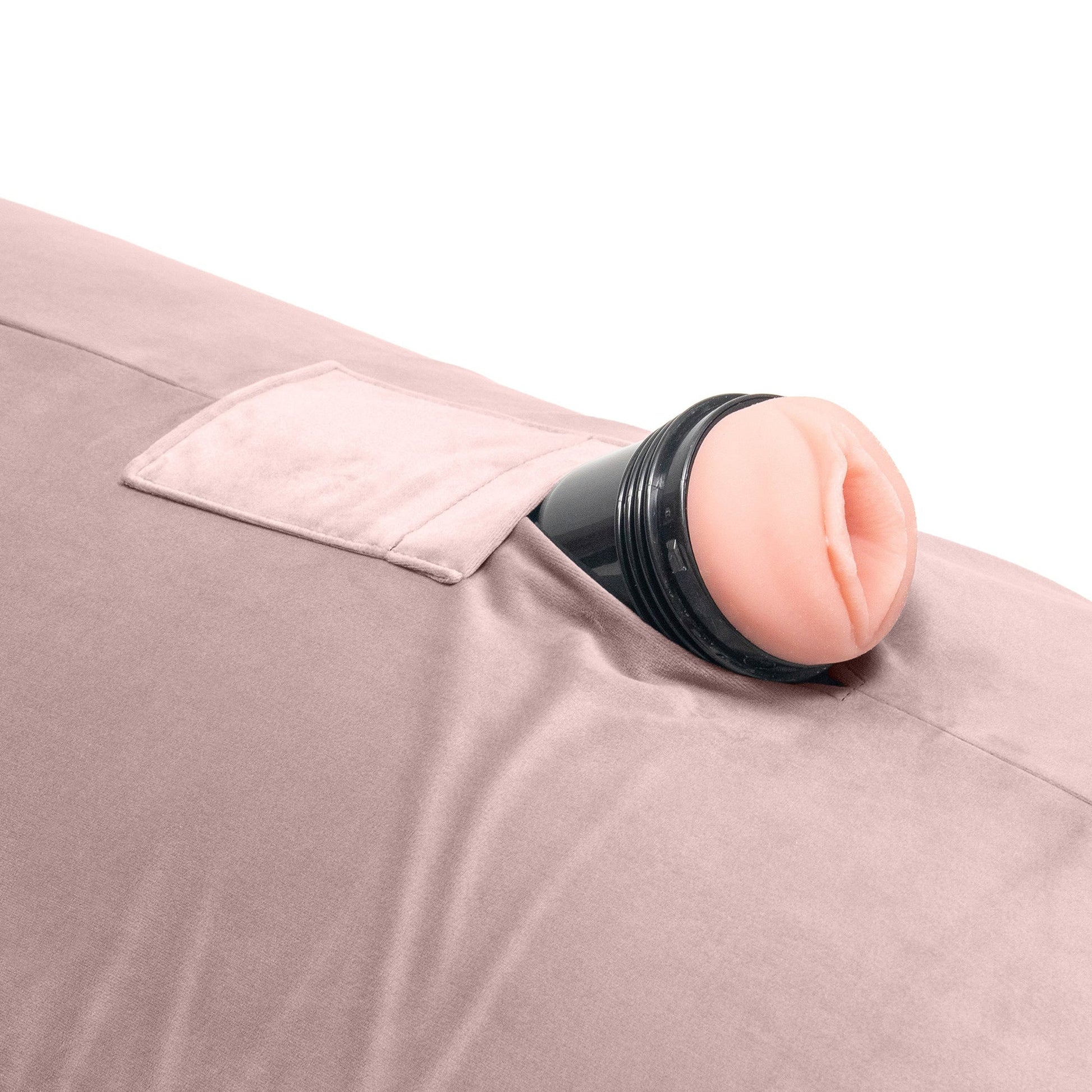 A close up of the mounting whole of a rose colored Humphrey Toy Mount pillow, Bedroom Furniture with a mens sleeve in it by Liberator against a white background.