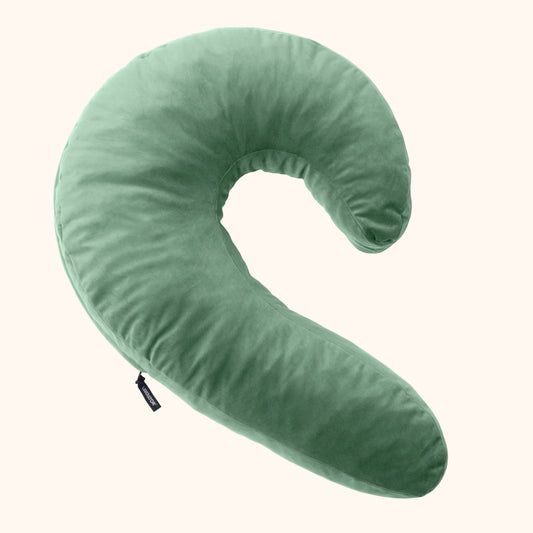 A sage Lune Snuggle curved Pillow, Bedroom Furniture by Liberator against a white background.