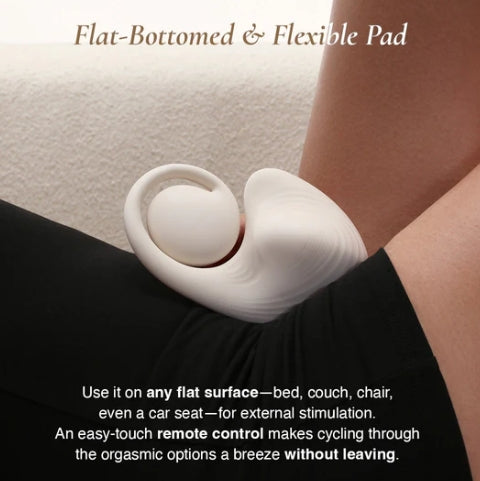 White flat-bottomed and flexible pad with remote control on a person's leg, used on a flat surface.