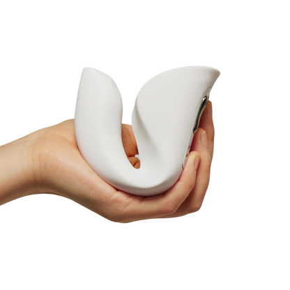 A hand holding a white Ridge Dual Action Vibrator by Liberator.
