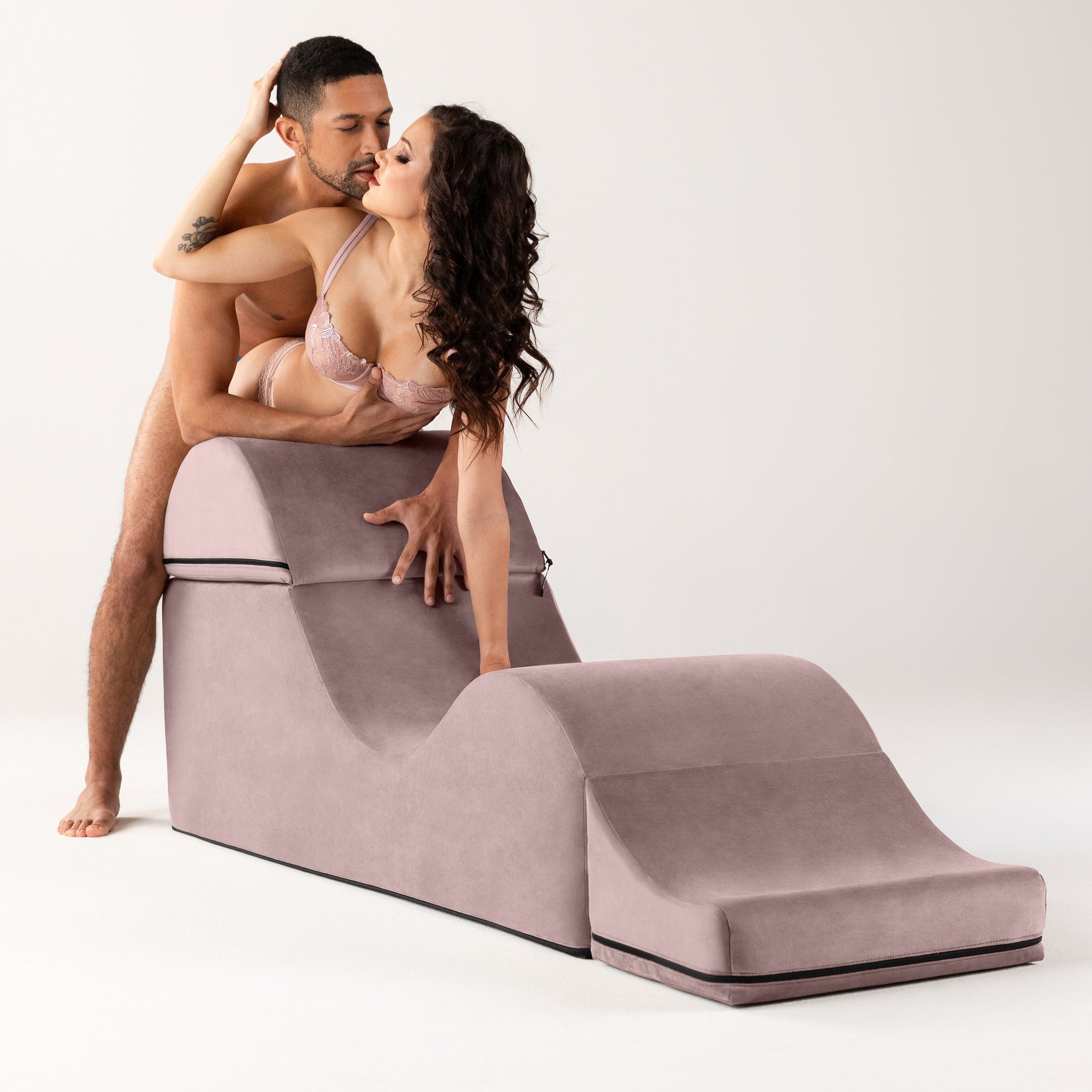 Rose Aria Flip Chaise by Liberator unfolded with a naked woman and man leaning on the back against a white background.