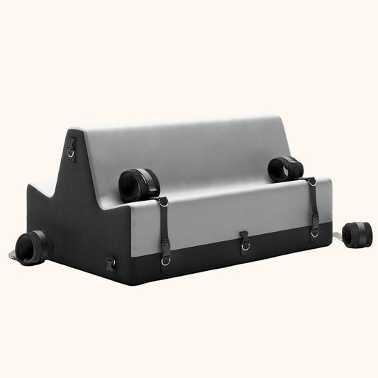 A grey and black Steed Spanking Bench bedroom furniture by Liberator  with cuffs against a white background.